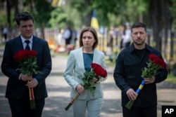 Президент України Володимир Зеленський (праворуч), президент Румунії Нікушор Дан (ліворуч) та президентка Молдови Мая Санду (в центрі) покладають квіти до меморіалу українським солдатам, загиблим у війні між Росією та Україною. Одеса, 11 червня 2025 року