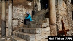 поломница ожидает у закрытых ворот храма Гроба Господня, Иерусалим, 25 февраля 2018 г․