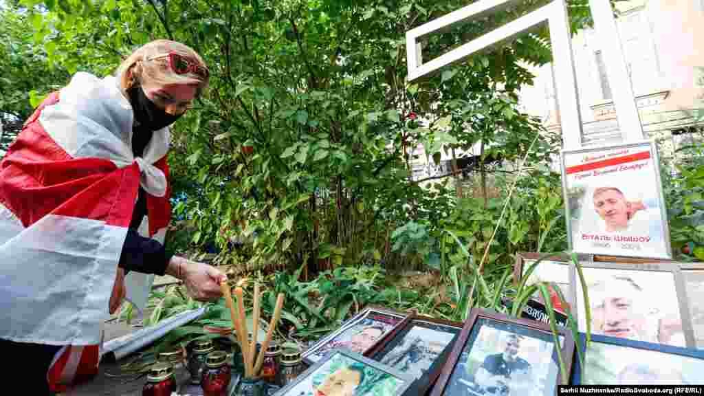 Жінка підпалює свічки біля&nbsp;пам&#39;ятного&nbsp;хреста жертвам&nbsp;режиму Лукашенка, неподалік&nbsp;будівлі посольства Білорусі в Києві&nbsp;