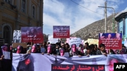 ық  Afghanistan -- Afghan members of the Solidarity Party of Afghanistan wearing masks bearing an impression of the bloodied face of a woman who was lynched by a mob chant slogans during a protest against the attack in Kabul, March 23, 2015