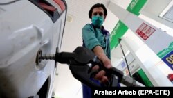 A gas-station attendant fills a car in Peshawar.
