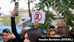 Протестиращи пред централата на "ДПС - Ново начало" държат плакат със задраскана буква "Д", 25 септември 2025 г.