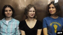 Pussy Riot тобының мүшелері Надежда Толоконникова (оң жақта),  Мария Алехина (ортада) және Екатерина Самуцевич (сол жақта) сотта отыр. Мәскеу, 17 тамыз 2012 жыл.