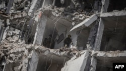 Ізраільскія выратавальныя каманды зь ліхтарыкамі і сабакамі шукаюць людзей у разбураным ад іранскага ўдару жылым доме, 15 чэрвеня 2025 году