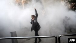 Жінка на території Тегеранського університету намагається врятуватися від дії сльозогінного газу, Іран, 30 грудня 2017 року