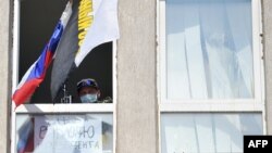 Пророссийский боевик в захваченном здании СБУ, Луганск, апрель 2014 года