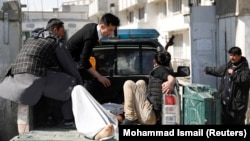 Men carry an injured person to the hospital after attacks mortar attacks in Kabul on March 7. 