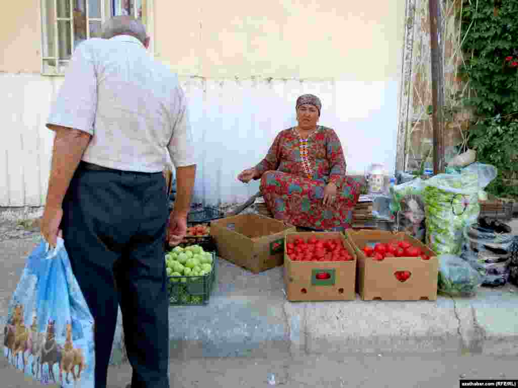 Köçede gök-bakça önümlerini satýan zenan.