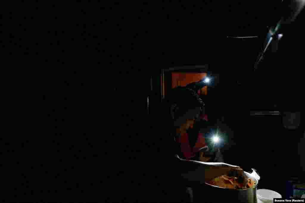 Кухар ресторану домашньої їжі навинос La Cocinona працює за допомогою телефонних ліхтариків під час відключення електроенергії в Мадриді, Іспанія, 28 квітня 2025 року