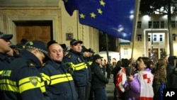 Співробітники поліції блокують демонстрантів з прапорами ЄС, які вимагають звільнення політичних в'язнів і проведення нових виборів у центрі Тбілісі, Грузія, 31 березня 2025 року