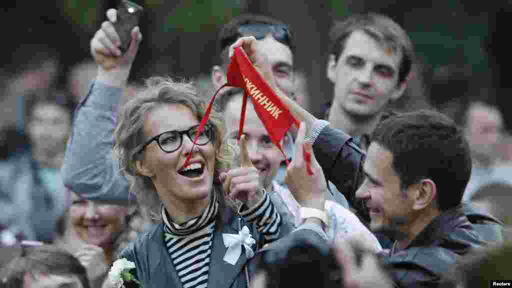 10 майда Мәскәүдә протест чаралары дәвам иткәндә протест шәһәрчегендә оппозиция тарафдарлары үзләре тәртип сакларга җына. Оппозиция җитәкчеләренең берсе Илья Яшин Ксения Собчакка тәртип саклаучы тамгасын күрсәтә.