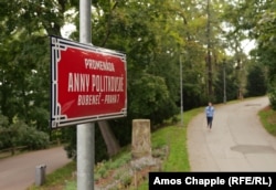 Жінка біжить уздовж алеї Анни Політковської. Паркан російського посольства розташований праворуч від цього зображення