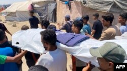 Газада чогулган палестиндер ооруканада иштеп жатканда өлтүрүлгөн беш журналисттин сөөгүн көтөрүп баратышат.  26-август, 2025-жыл. 