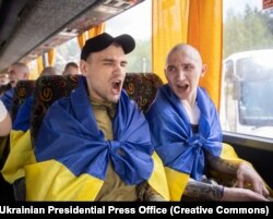 Звільнені з полону українські військовослужбовці співають гімн України в автобусі, що везе їх від пункту обміну...9 червня 2025 року