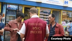 Ռուսաստան -- Ռուս պաշտոնյան ստուգում է ներգաղթյալների փաստաթղթերը, արխիվ