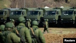 Զինված մարդիկ, ենթադրաբար, ռուսաստանցիներ, քայլերթ են անցկացնում Սիմֆերոպոլի շրջանում տեղակայված ուկրաինական ռազմակայանի մոտ, 17-ը մարտի, 2014թ.
