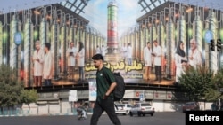 Мъж минава покрай билборд в Техеран, който показва ирански ядрени учени, убити в удари на Израел, 29 август 2025 г.