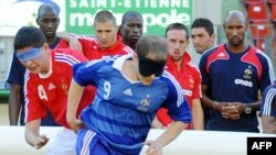 Члены национальной сборной Франции по футболу наблюдают за игрой команды французской Ассоциации слепых и слабовидящих футболистов (2 июня 2009 года).