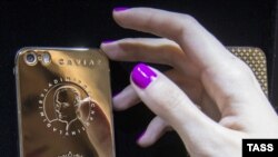Cмартфон iPhone с золотым покрытием корпуса и портретом президента России Владимира Путина. Россия. 