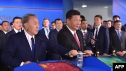 Қазақстан президенті Нұрсұлтан Назарбаев (сол жақта) пен Қытай президенті Си Цзиньпин 
Назарбаев Батыс Қытай - Батыс Еуропа бағыты бойынша жаңа контейнерлік жүк тасымалы бағытын ашу рәсімінде тұр. Астана, 8 маусым 2017 жыл.