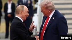 Президент США Дональд Трамп пожимает руку главе России Владимиру Путину во время их встречи для переговоров о прекращении российско-украинской войны в Анкоридже. США, Аляска, 15 августа 2025 года