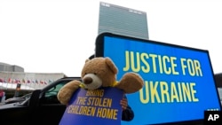 Іграшка з плакатом «Поверніть вкрадених дітей додому» біля штаб-квартири ООН, 23 лютого 2023 року