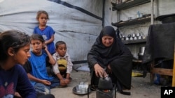 غالیه ابو مطیر در کنار نوه‌هایش در یک اردوگاه چادری