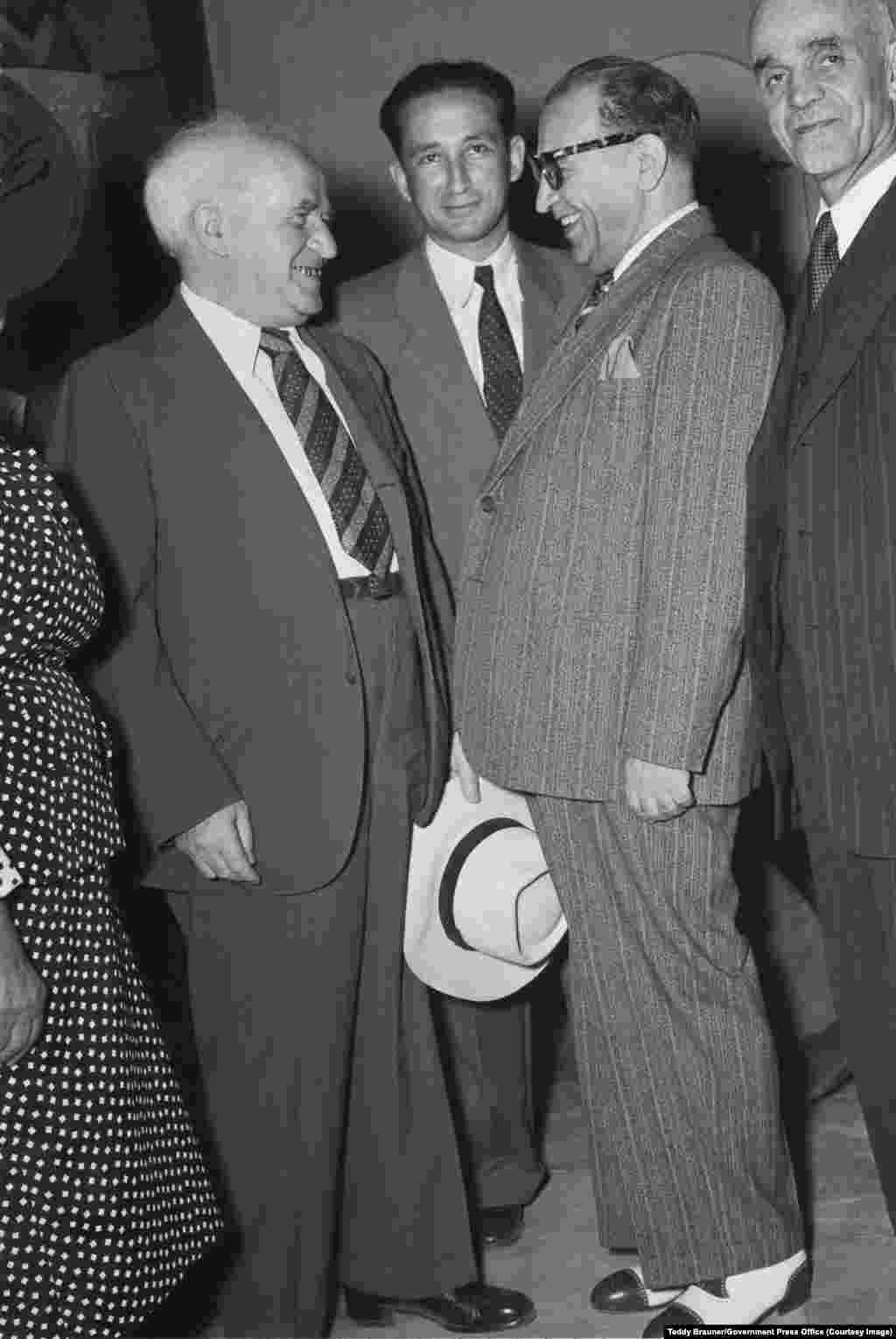 حضور دیوید بن گوریون (چپ)، اولین نخست‌وزیر اسرائیل، در یک مهمانی که سال ۱۹۵۰ توسط هیئت ایرانی در اورشلیم برگزار شد. او در این‌جا با رضا صفی‌نیا (در کت راه‌راه) گفت‌وگو می‌کند.روابط میان دو کشور آن‌قدر گرم شد که در نهایت پروازهای روزانه بین تهران و تل‌آویو برقرار شد. ایران و اسرائیل حتی مخفیانه با هم همکاری می‌کردند تا یک سامانه موشکی مشترک را توسعه دهند.