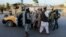 Afghan security officials stop people at a checkpoint in Kandahar on June 8.