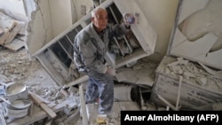 Мешканець містечка Кафр-Батна у Східній Гуті показує фото родини, врятоване з руїн його дому після повітряного удару, 1 березня 2018 року