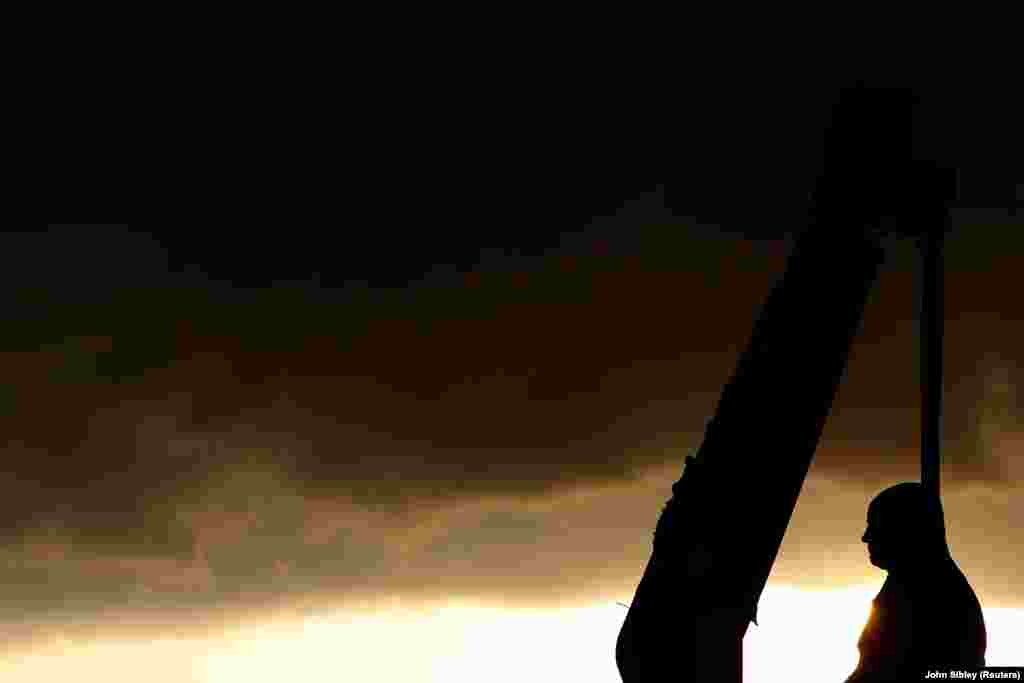 Силует пам&rsquo;ятника Робертові Мілліґану під час його знесення 9 червня 2020 року. Пам&rsquo;ятник стояв перед Музеєм лондонських доків у районі Канарі-Ворф. Мілліґан став засновником лондонських доків, які проіснували до 1980-х років. Цей пам&rsquo;ятник йому звели невдовзі після його смерті 1809 року.