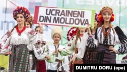 Представлення традиційного українського народного одягу в Молдові на фестивалі «IaMania». На плакаті напис: «Українці з Молдови». Село Голлеркані, що за 52 кілометри на північний схід від Кишинева, 9 липня 2016 року