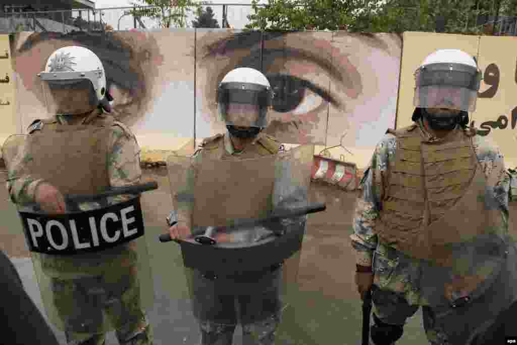 Afghan police stand guard during the protest.