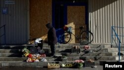 A woman sells vegetables on the steps of a closed supermarket amid Russia's attack on Ukraine in Pokrovsk in Ukraine's eastern Donetsk region on October 28.