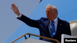 US President Donald Trump gestures while he boards Air Force One, in Abu Dhabi, United Arab Emirates, on May 16.