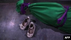 کفش‌های دختر سه ساله در کنار تن بی‌جانش در حاشیه شرقی حلب. «حیا»، چند ساعت پیش از پایان سال ۲۰۱۶ در بمباران کشته شد.