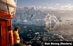 یک گردشگر در حال تماشای نمایی از بندر «دیسکو» در گرینلند، ماه مه ۲۰۰۷