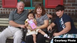 Токмок шаарындагы балдар үйүнөн америкалыктар асырап кеткен Элли-Аймана Латтэм ата-энеси, байкеси менен. Теннесси штаты, 2011-жыл.   