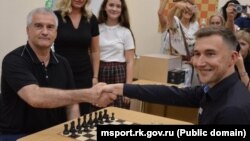 Шахматист Сергей Карякин с российскими главой Крыма Сергеем Аксеновым во время открытия шахматной школы в Симферополе, 4 августа 2023 года