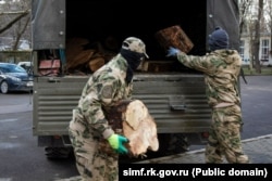 Російські військові у Сімферополі завантажують спиляні дерева в межах акції «Бліндажі в теплі», лютий 2025 року