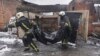 Firefighters carry the body of a local resident killed after a Russian drone hit his home in a residential neighborhood in Kharkiv on February 10.