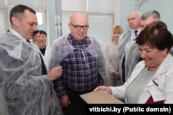 Старшыня Віцебскага аблвыканкаму Аляксандар Субоцін(зьлева), дырэктар завода Аляксандар Шумахер(у акулярах) разам са старышынёй савета дырэктароў віцебскага завода «Маналіт» Акіфам Гасымавым(справа) падчас наведваньня вытворчасьці ў сакавіку 2024 года.