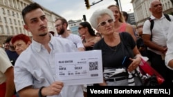 Протестиращ с плакат, който имитира самолетен билет до Сицилия. Това е препратка към изказване на депутата от ИТН Тошко Йорданов, който каза, че ако на младите лекари не им харесва в България, могат да заминат за чужбина