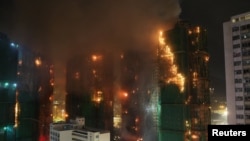 Пожежники працюють над гасінням полум'я на кількох будівлях у житловому масиві Ван Фук Корт, Гонконг, Китай, 26 листопада 2025 року.