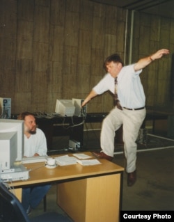 Марио Корти (директор Русской службы в 1998-2005 годах) взлетает на стол Игоря Померанцева. Прага, 1995. Фото Ивана Толстого.