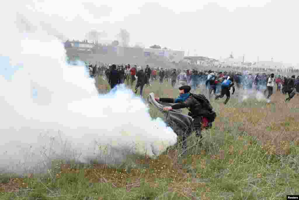 Біженець намагається прикрити ковдрою димову шашку