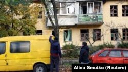 Люди дивляться на пошкоджений російським ударом житловий будинок у Києві, 22 жовтня 2025 року