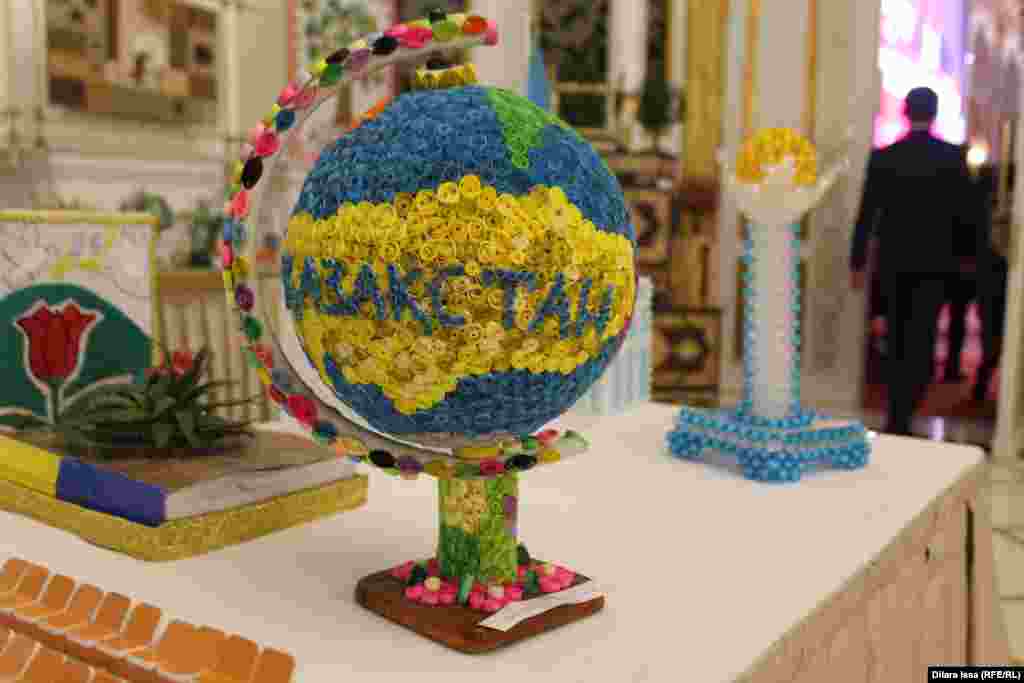 Түрлі-түсті қағаздан жасалған глобустағы Қазақстан атауы мен картасының пішіні.