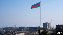Azerbaijan -- An enormous Azerbaijani flag flies above the construction site of the 2012 Eurovision concert hall on the Caspian Sea shoreline in Baku, 14Jan2012