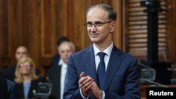 Serbian Prime Minister Djuro Macut smiles after his swearing-in ceremony at the parliament in Belgrade on April 16. 